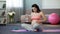 Lady in final stages of pregnancy doing yoga, drinking water, safe childbirth