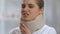 Lady in foam cervical collar suffering from strong neck pain, rehabilitation