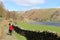 Lady on footpath by dry stone wall, Watendlath