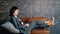 Lady freelancer sits on brown bench with grey cushion