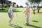 Lady golfer on the putting green at the eighteenth hole with partner