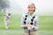 Lady golfer smiling at camera with partner behind