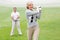 Lady golfer teeing off for the day watched by partner