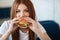 Lady with a hamburger for a table in a cafe