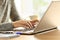 Lady hands typing in a laptop on a desk