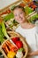 Lady holding basket mixed vegetables