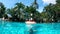 A lady is jumping into a floating ring in the pool