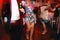 Lady with long tanned legs dances in a restaurant hall