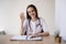 lady looking at the camera greeted during a consultation on telemedicine, consults a patient in a virtual meeting