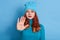 Lady making stop gesture with her palm, posing over blue background, looks strict and serious, wearing sweater and cap, has red