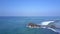 Lady meditates on large rocky cliff at endless blue ocean