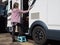 A lady motorhome owner uses a small step to enter her motorhome using the side habitation door.Image