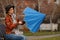 Lady opening blue umbrella