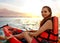 Lady paddling the kayak in the calm tropical bay at sunset