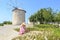 Lady in pink looking flowers among windmills in Alacati, Cesme