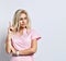 Lady in pink suit, smart watch, jewelry posing isolated on white. She raised her index finger up and looking thoughtful. Close up