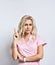 Lady in pink suit, smart watch, jewelry posing  on white. She raised her index finger up and looking thoughtful. Close up