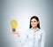 Lady presents a light bulb as a concept of new idea in business.