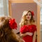 Lady in red dress with flower barrette looking in