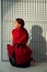 Lady in red kneeling down in studio.