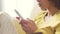 Lady replying to text message. Closeup of womans hands texting on phone while sitting on a couch at home. Zoom in on a