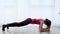 Lady in retro leotard stands in advanced plank position