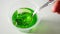 Lady\'s hands using spoon to scoop green jelly on dining table in slowmotion