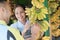 Lady shop assistant offers bananas to customers at a fruit stand