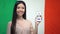 Lady showing cellphone with learn Italian app, flag on background, education