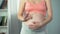 Lady showing ok hand sign and touching her pregnant belly tenderly, healthcare