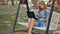 Lady Sits on Swing with Iphone and Laptop on Knees