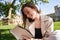 Lady is sitting on a park bench and reading book