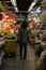 A lady stands with her back to camera in an isle of Sheung Shui market