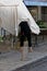 Lady struggling to raise  a large parasol on Isle de Re France.