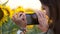 Lady tourist takes photo of bright sunflower on phone camera