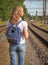 Lady traveler with a backpack behind her on the train tracks in a small European city.