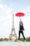 Lady with umbrella posing in front of Eiffel Tower, sky background. Lady tourist sporty and active walks in Paris city