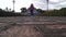 Lady walks over camera toward old cemetery low angle shot