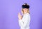 Lady with weapon gesture. Enthralling interaction virtual reality. Woman head mounted display violet background. Virtual