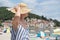 Lady wearing striped summer dress and straw hat relaxing on vaction enjoying view over beach at Moscenicka Draga, Istria