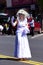 Lady in White at Parade Waving at Crowd