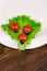 Ladybug made of raw tomato on lettuce leaf