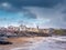 Lahinch, Ireland -01.14.2023: Sandy beach and waterfront buildings. Blue cloudy sky. Popular resort on Atlantic ocean