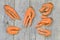 Laid out carrots of non-standard shape on a gray wooden rustic background. Concept ugly vegetables