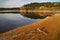 Lake in autumn landscape, on the bank of the wooden root