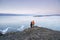 Lake Baikal at winter. Couple travelers standing on top of mountain and looking at frozen Baikal lake