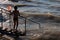 Lake Balaton in backlight - Silhouette of a bathing young boy holding a fishing landing net