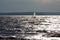 Lake Balaton in backlight with silver waves and a silhouette of a windsurfer