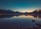 Lake Bled at Sunrise. Church, castle and the mountains are basking in the morning sun