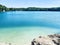 Lake with blue water in the forest. Flooded quarry